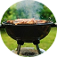 Черный гриль на открытом воздухе, заполненный шипящим мясом, окруженный зеленью и испускающий струйки дыма.